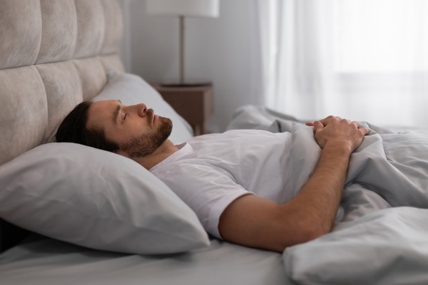  Mand, der sover på ryggen med en pude