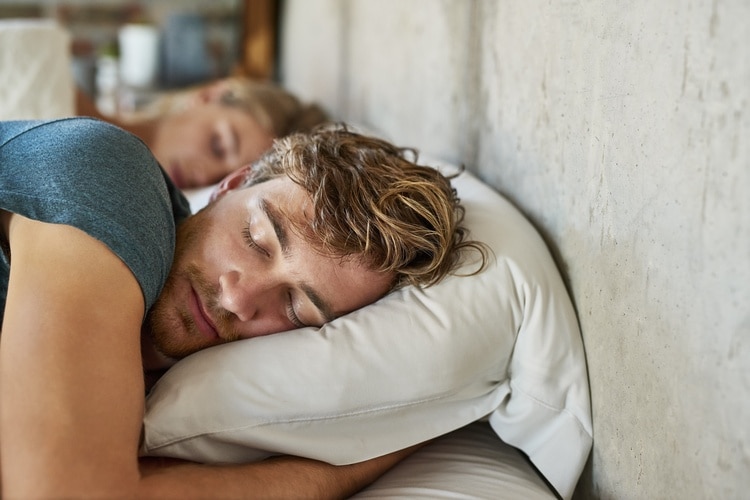 Mand, der sover på siden med en pude