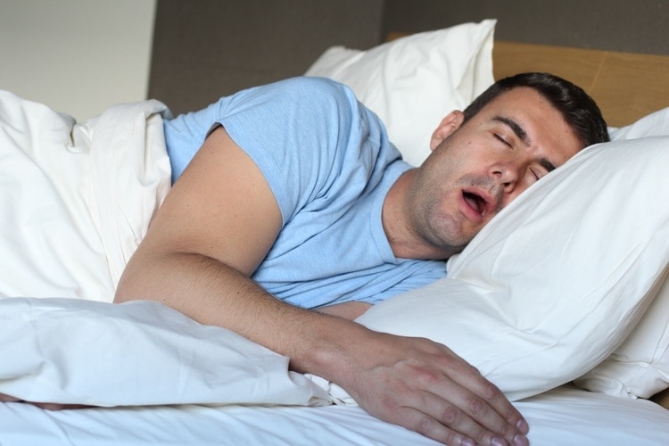 Mand, der sover med åben mund