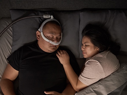 En patient, der bærer en ResMed AirFit P30i nasalpudemaske.